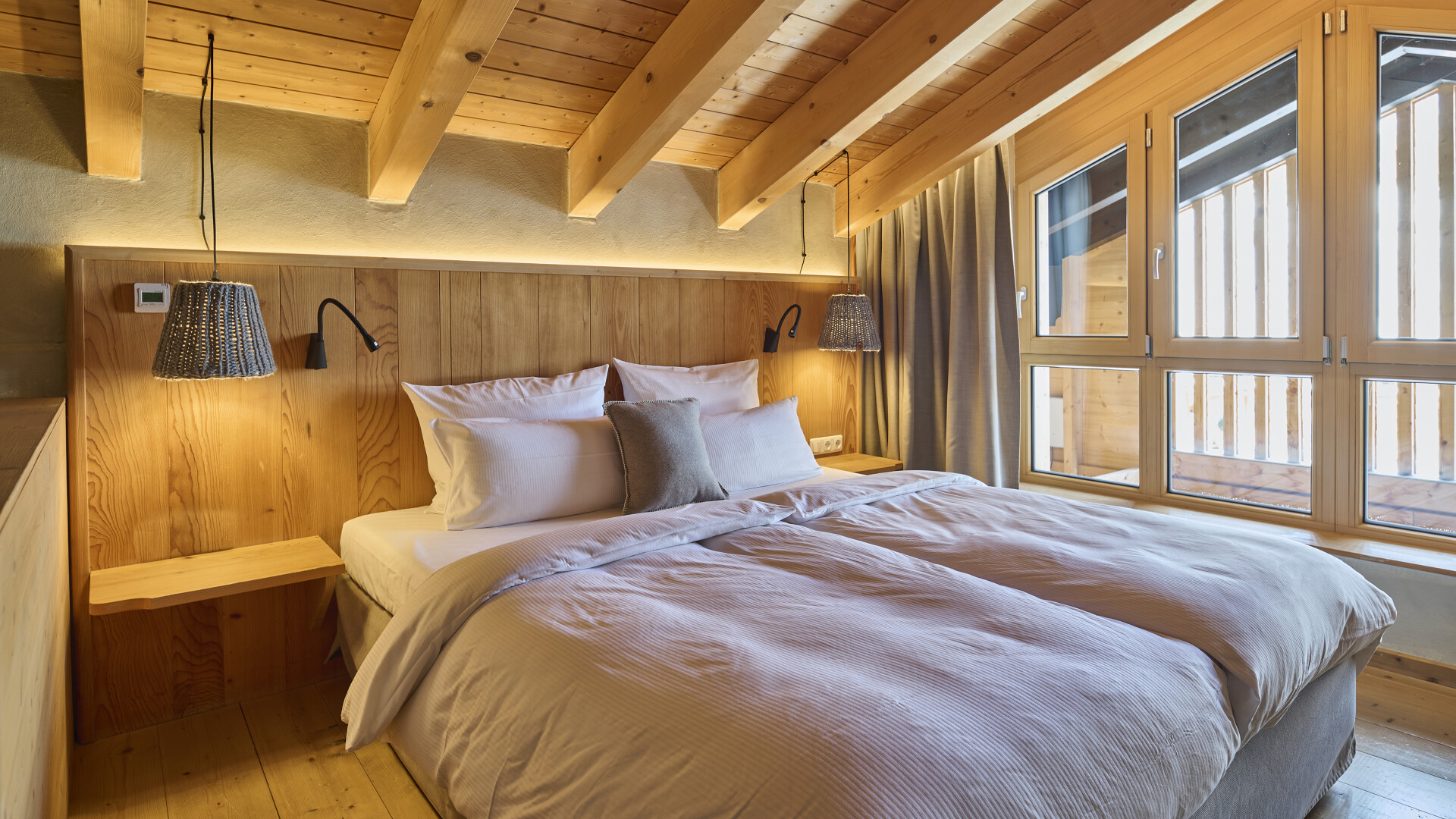 Zimmer auf zwei Etagen mit Doppelbett und Glasfront ins Tal
