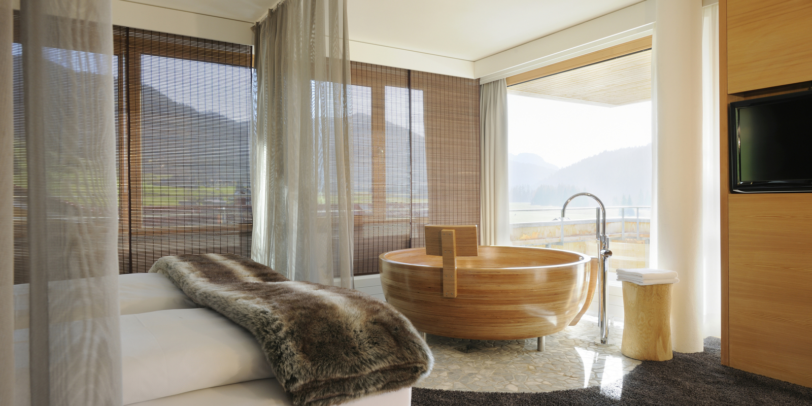 Besondere und großzügige Suite mit Schlaf- und Wohnraum und freistehender Holzbadewanne.