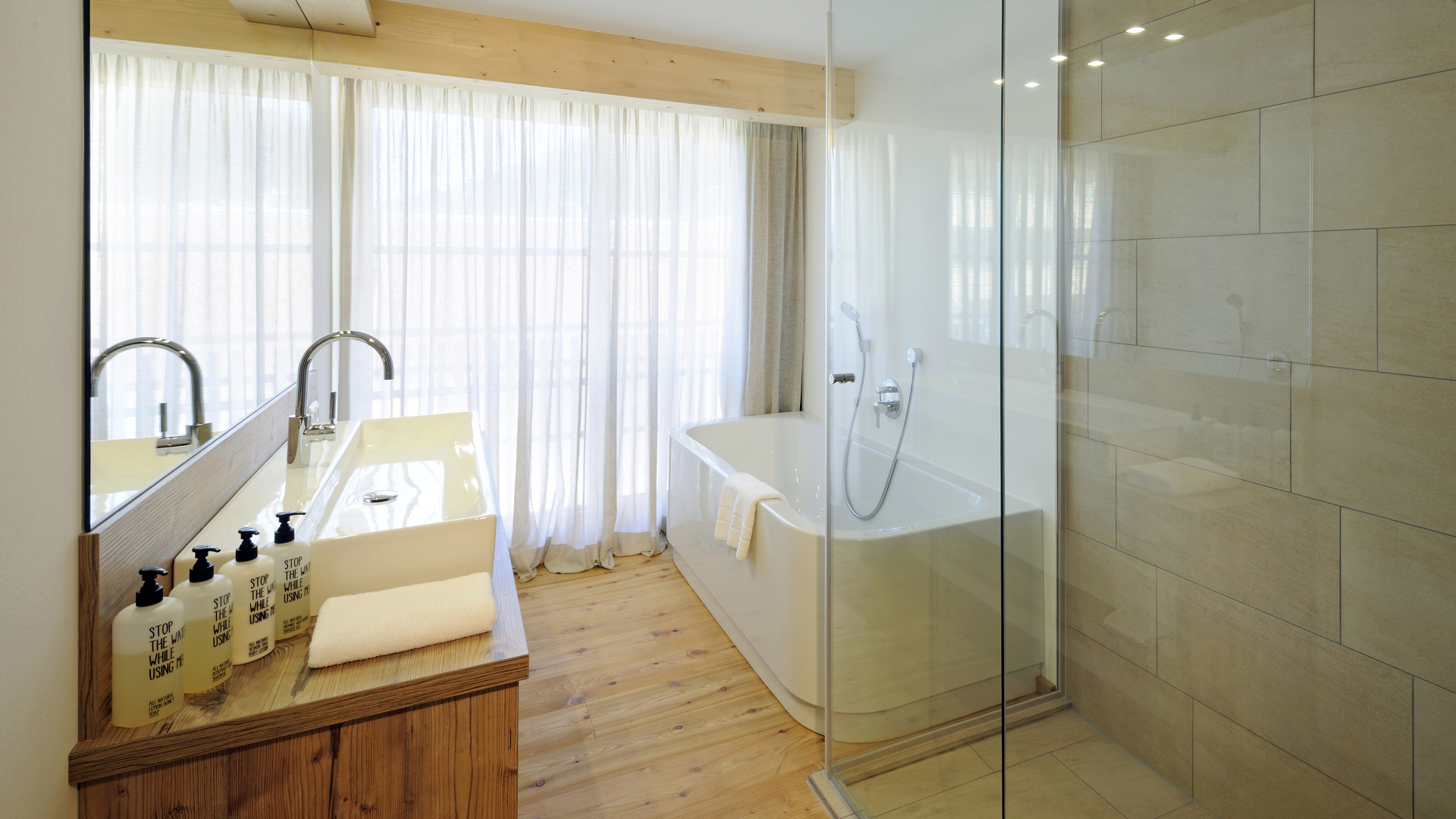 Großes Badezimmer mit Badewanne für eine romantische Auszeit im Wellnesshotel HUBERTUS