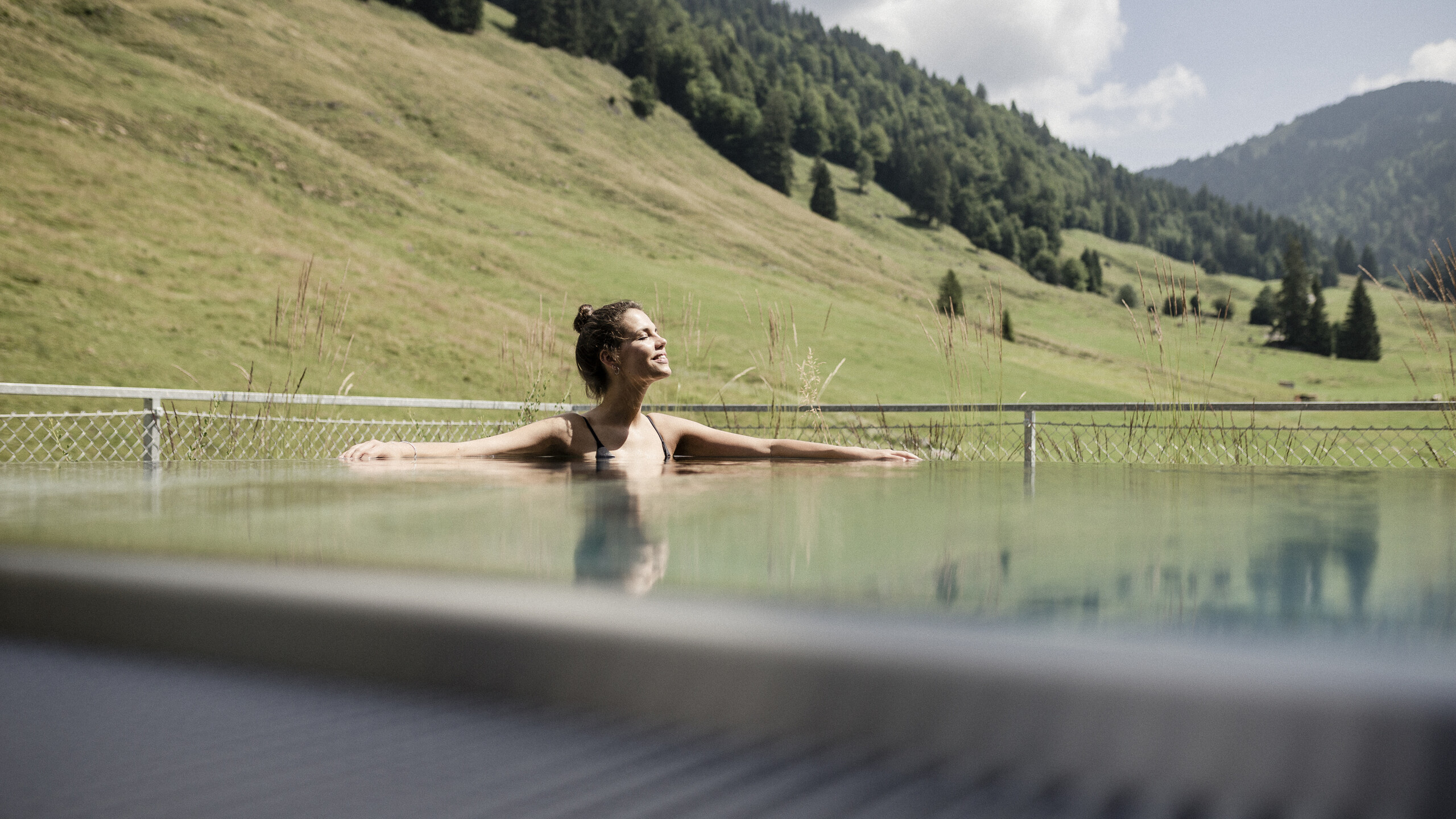 Junge Frau im japanischen Onsen-Becken im Wellnesshotel HUBERTUS